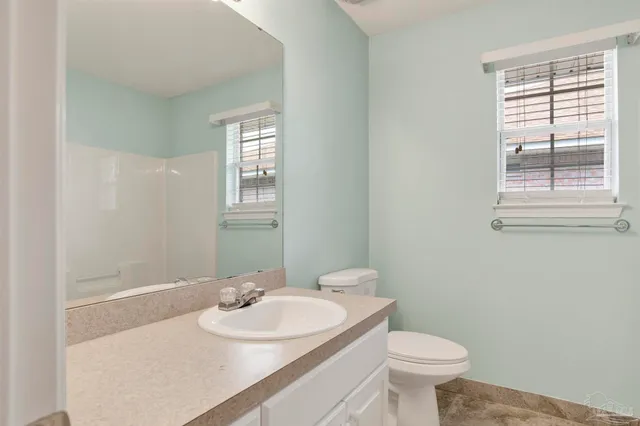 a bathroom with a sink a toilet and a window