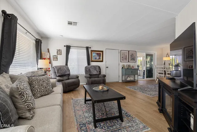 a living room with furniture and wooden floor