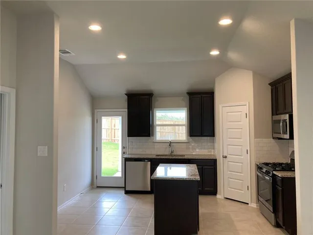 a kitchen with stainless steel appliances granite countertop a sink and stove top oven