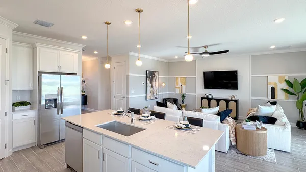 a view of a kitchen with kitchen island stainless steel appliances a sink and living room view