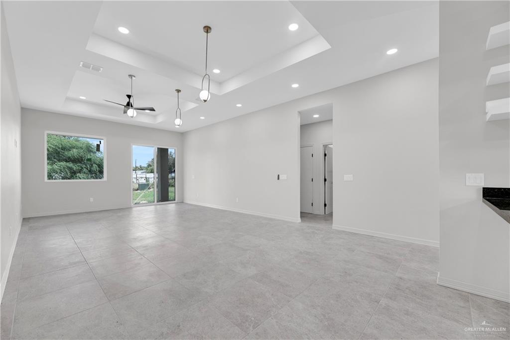 425 South 12th Street Alamo, TX 78516 - Photo 6 of 15 an empty room with a open kitchen and window