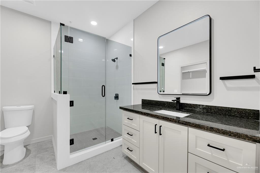 425 South 12th Street Alamo, TX 78516 - Photo 8 of 15 a bathroom with a granite countertop sink mirror and toilet