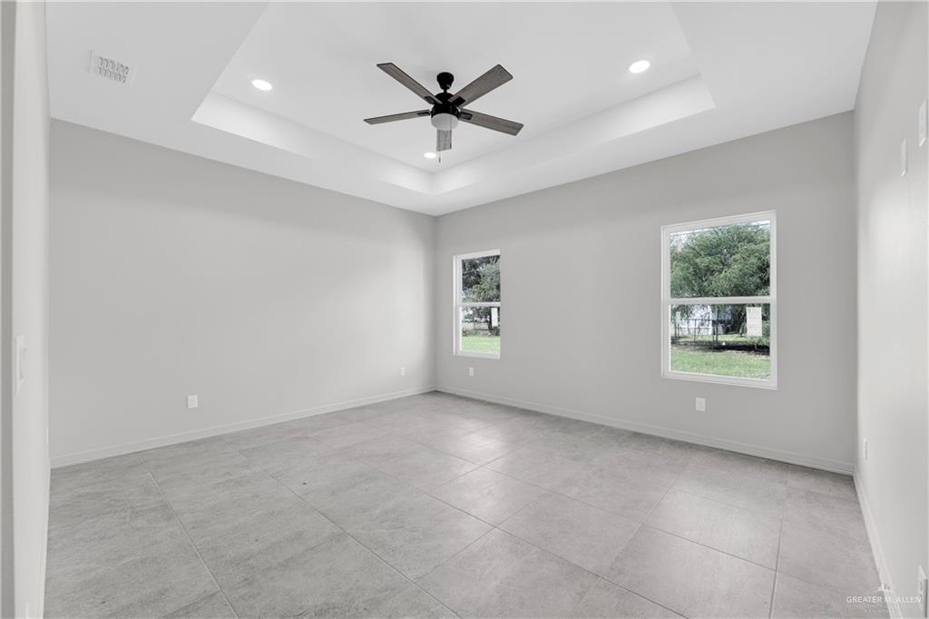 425 South 12th Street Alamo, TX 78516 - Photo 10 of 15 an empty room with ceiling fan and windows