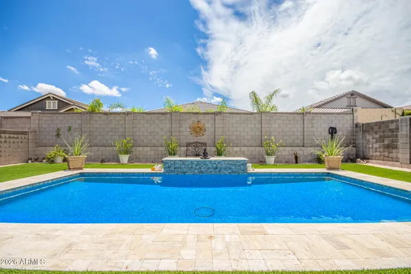 a view of a swimming pool with a lawn chairs under an umbrella