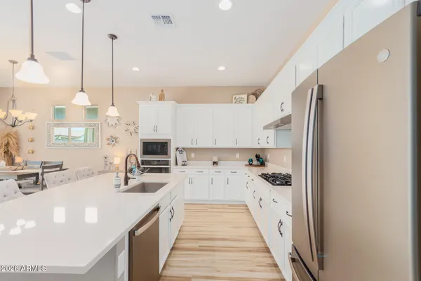 a kitchen with stainless steel appliances a stove a sink a oven and a refrigerator with wooden floor