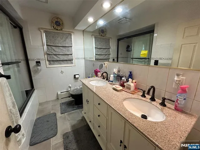 a bathroom with double vanity sink and a mirror