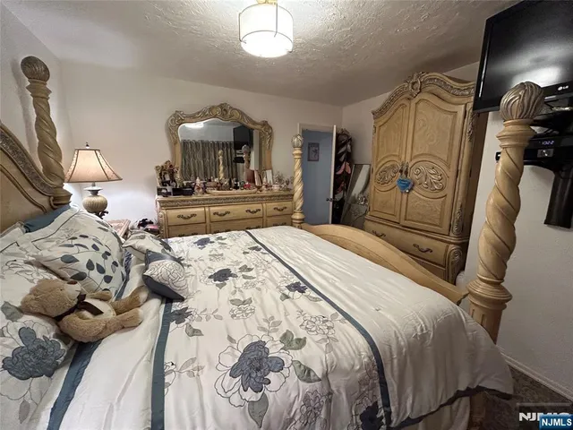 a bedroom with a bed and a mirror on dresser
