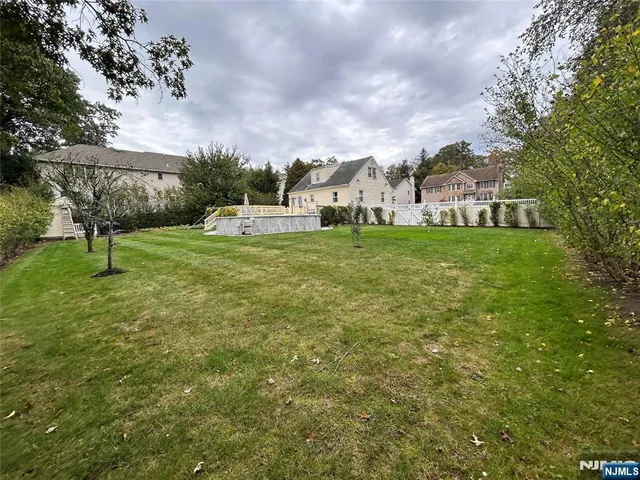 a view of a big house with a big yard and a large tree