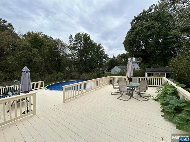 a view of deck with furniture and trees