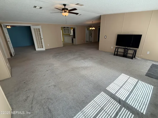a view of a big room with closet and windows