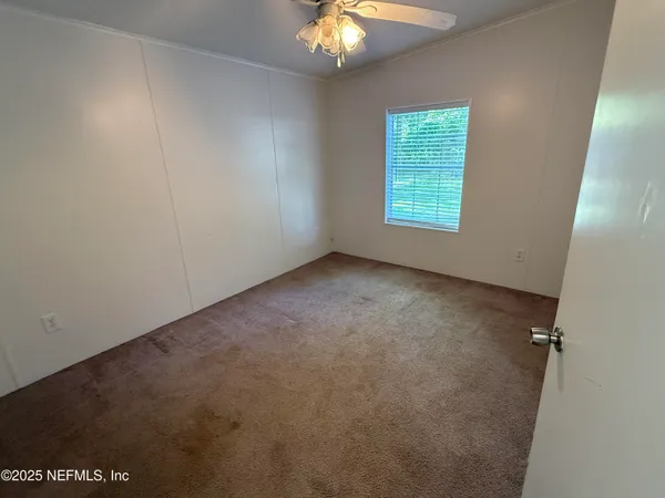 a view of a room with a ceiling fan and closet