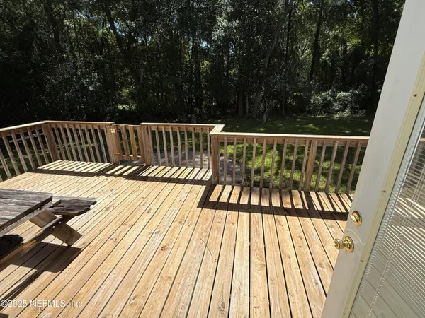 a view of balcony with wooden floor and fence