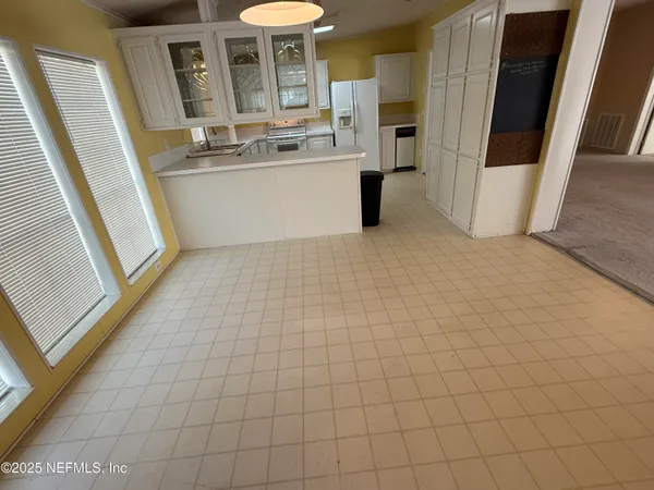 a view of kitchen with furniture and refrigerator