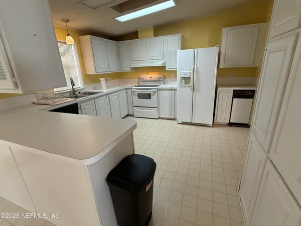 a kitchen with granite countertop a refrigerator and a sink
