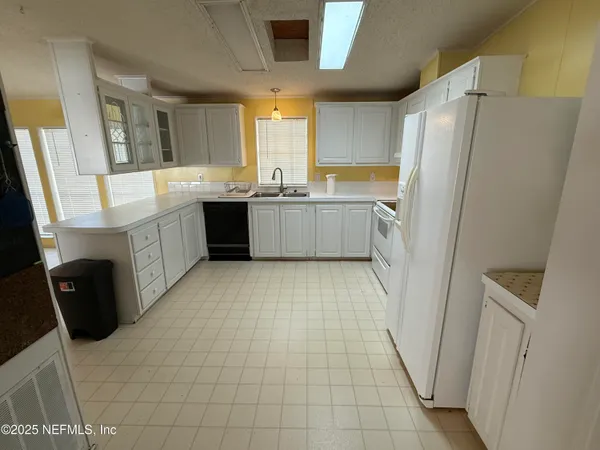 a large kitchen with a sink a refrigerator and a stove