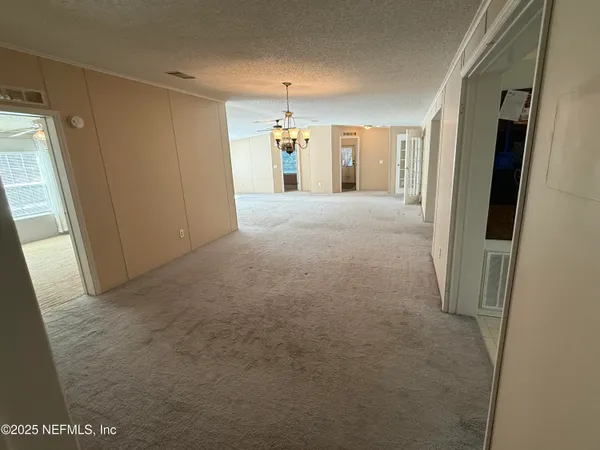 a view of a hallway with furniture and a window