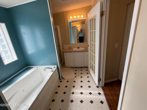 a bathroom with a tub sink and a mirror