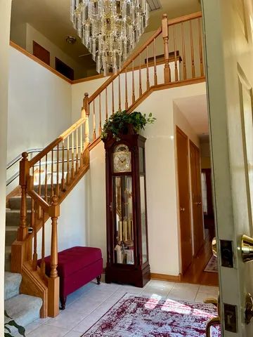 a view of staircase with a rug and a chandelier