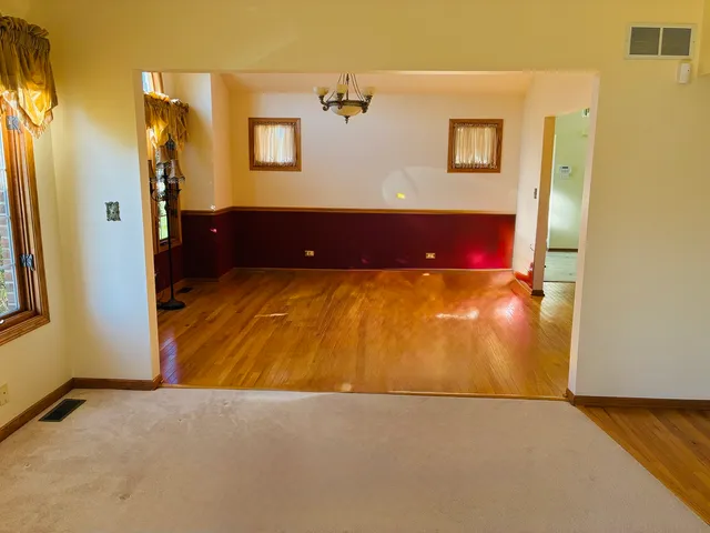 a view of a bedroom with a window and wooden floor