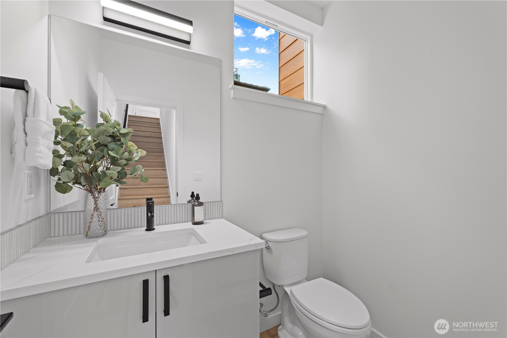 1704 North 47th Street Seattle, WA 98103 - Photo 17 of 38 a bathroom with a sink a toilet and mirror