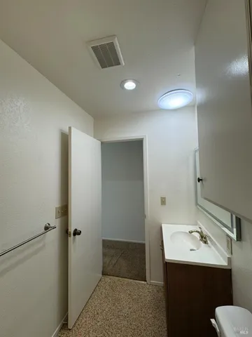 a bathroom with a sink toilet and mirror