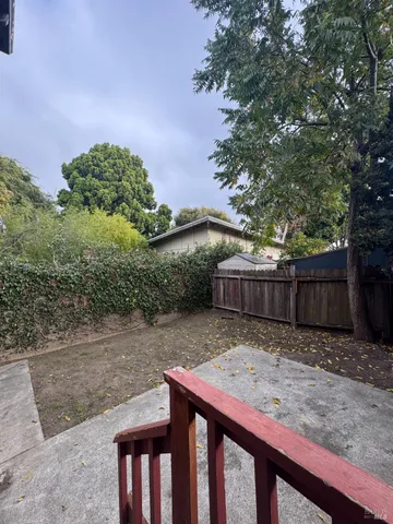 a backyard of a house with basket ball court tables and chairs