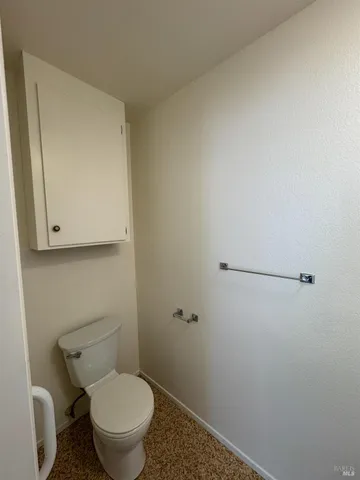 a white toilet sitting next to a shower