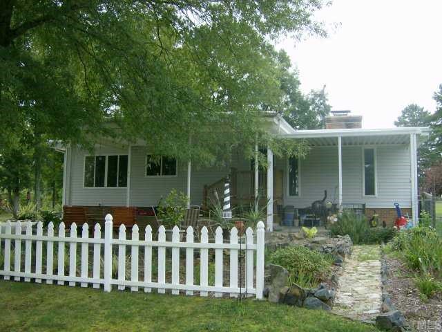 375 Chambers Loop Road Timberlake, NC 27583 - Photo 10 of 12 SIDE VIEW SHOWS FENCING BEHIND THE PATIO, CARPORT, AND COVERED ROOF TO BASEMENT