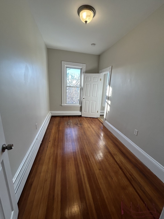 279 Webster Street, Unit 2 Boston, MA 02128 - Photo 18 of 20 an empty room with wooden floor and windows