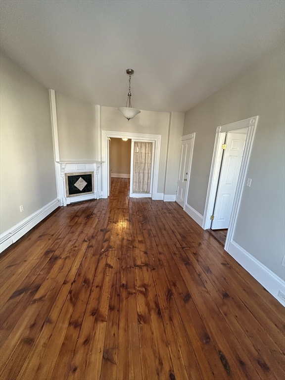 279 Webster Street, Unit 2 Boston, MA 02128 - Photo 2 of 20 a view of empty room with wooden floor and fireplace