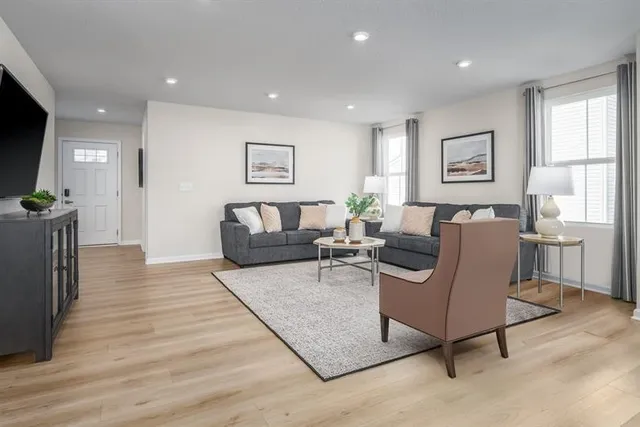 a living room with furniture and a wooden floor