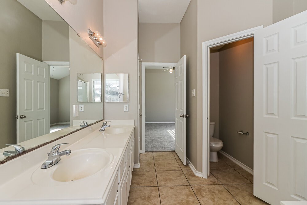 16419 Great Ridge Court Houston, TX 77083 - Photo 11 of 16 a bathroom with a tub sink and mirror