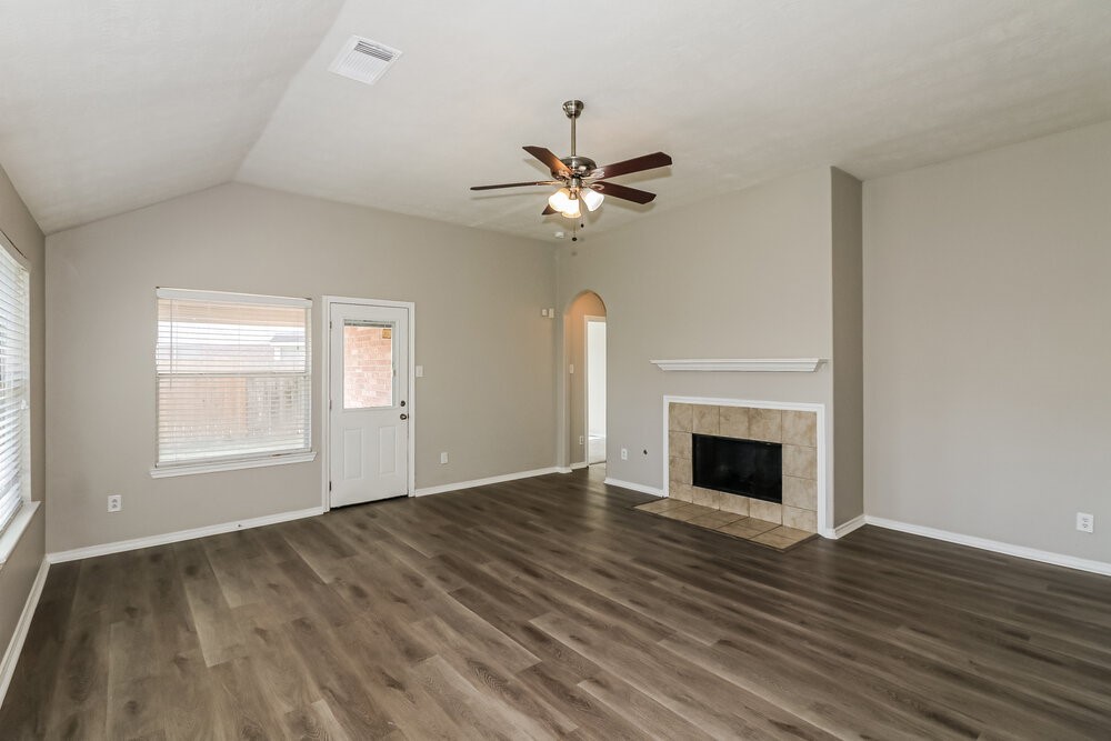 16419 Great Ridge Court Houston, TX 77083 - Photo 4 of 16 an empty room with wooden floor fan and windows