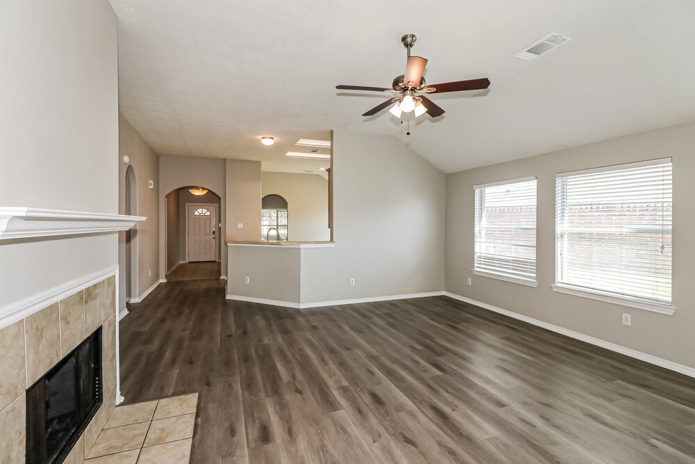 16419 Great Ridge Court Houston, TX 77083 - Photo 5 of 16 a view of a livingroom with a fireplace a ceiling fan and wooden floor