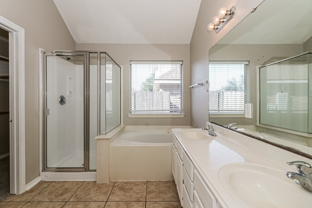 16419 Great Ridge Court Houston, TX 77083 - Photo 10 of 16 a spacious bathroom with a tub sink and mirror