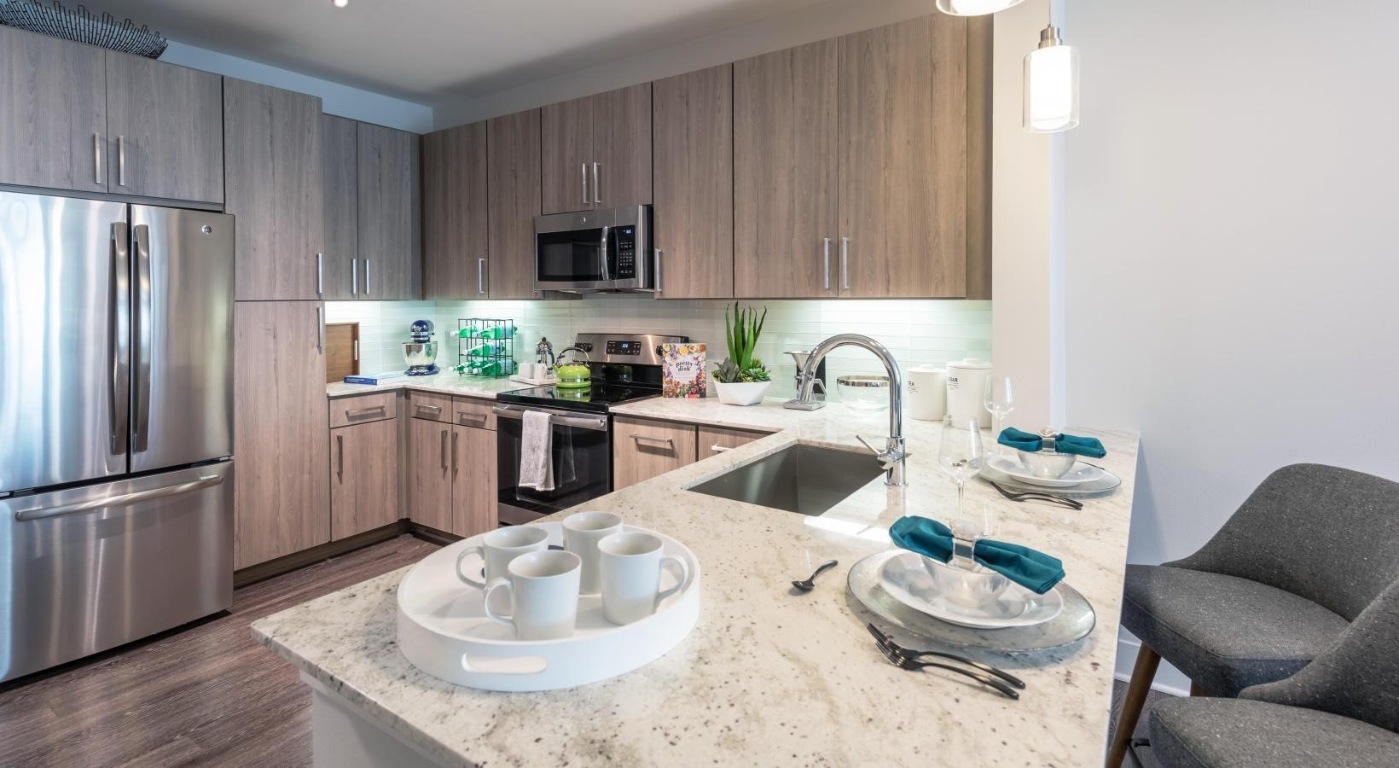3100 Kramer Lane, Unit 245 Austin, TX 78758 - Photo 6 of 20 a kitchen with stainless steel appliances granite countertop a sink a stove a microwave and a refrigerator