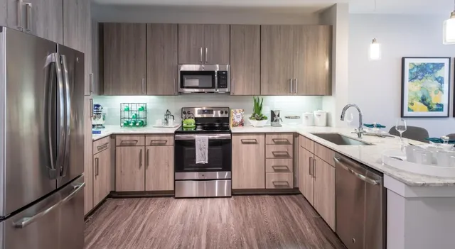 a kitchen with a sink white cabinets and stainless steel appliances