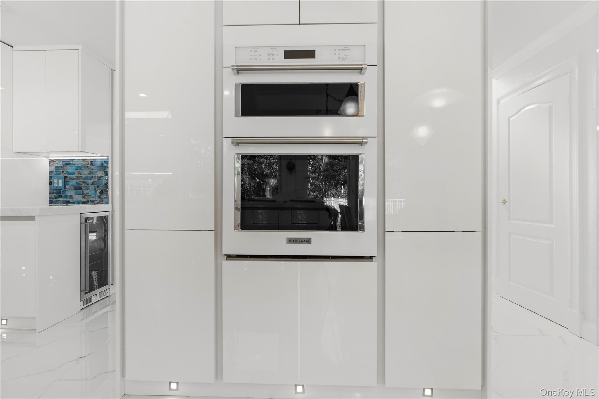 28 Annandale Road Commack, NY 11725 - Photo 6 of 29 Kitchen with white cabinets, double oven, modern cabinets, beverage cooler, and light marble finish flooring