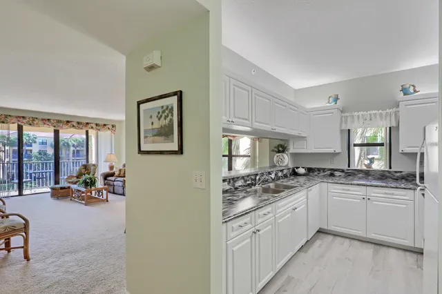 a kitchen with stainless steel appliances granite countertop a sink a stove cabinets and a window