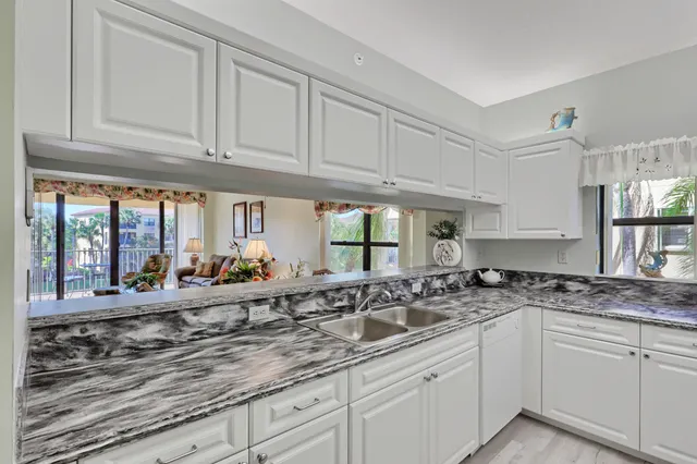 a kitchen with granite countertop white cabinets and white appliances