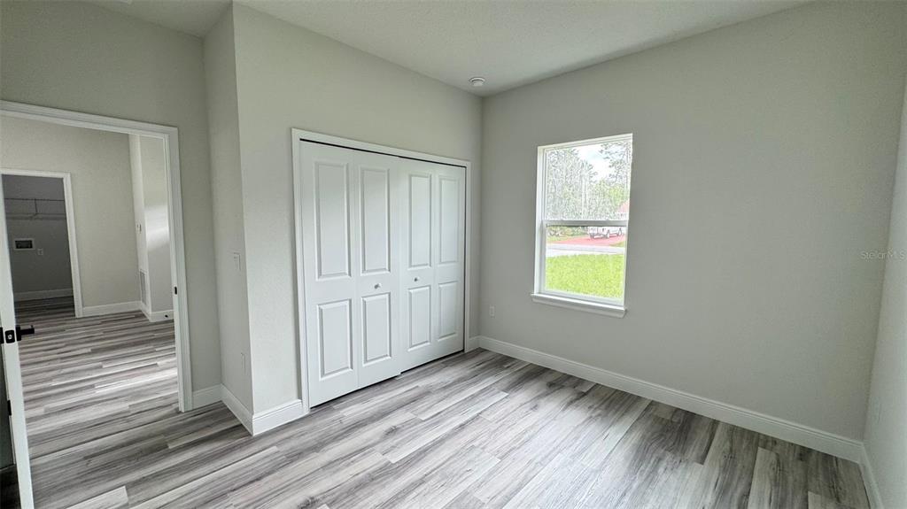 16884 Southwest 39th Circle Ocala, FL 34472 - Photo 13 of 29 a view of an empty room with wooden floor and a window