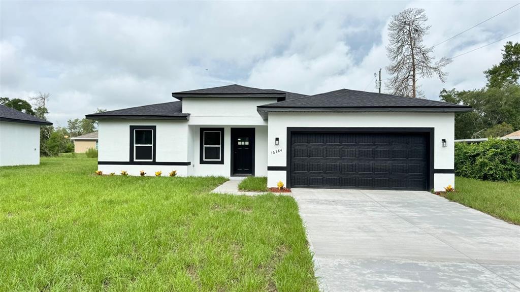 16884 Southwest 39th Circle Ocala, FL 34472 - Photo 29 of 29 a front view of a house with a yard and garage