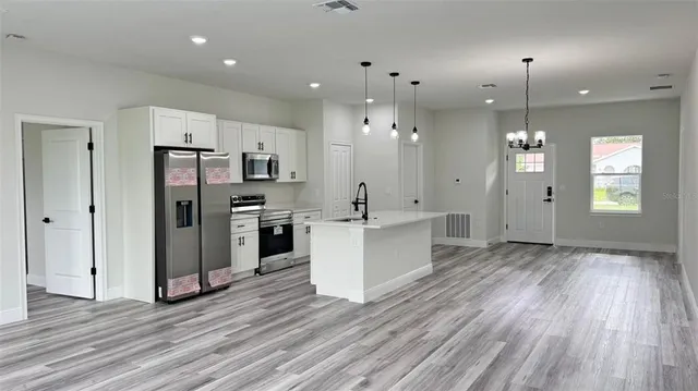 a view of a kitchen with refrigerator microwave and wooden floor