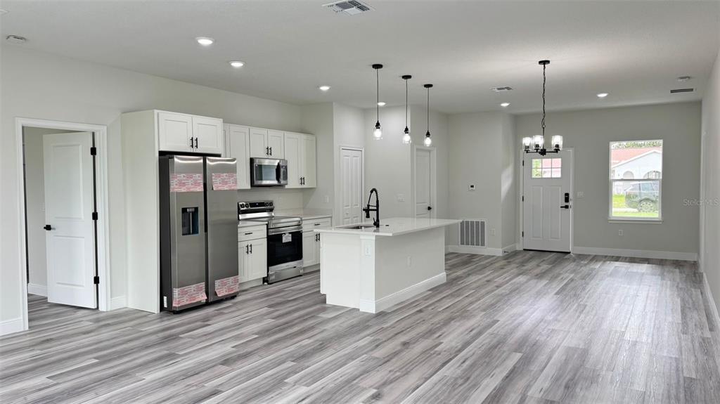 16884 Southwest 39th Circle Ocala, FL 34472 - Photo 5 of 29 a view of a kitchen with refrigerator microwave and wooden floor