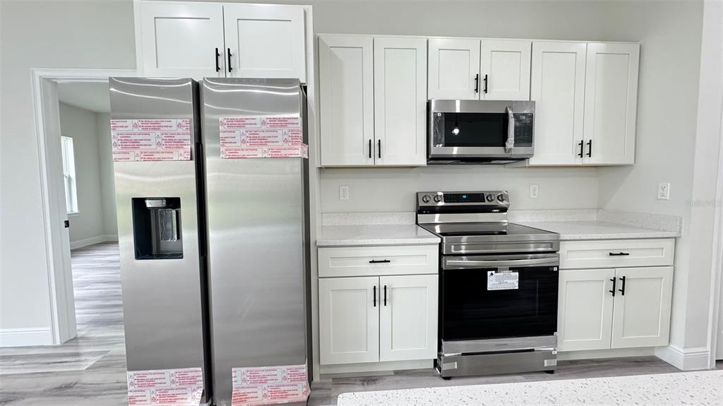 16884 Southwest 39th Circle Ocala, FL 34472 - Photo 8 of 29 a kitchen with stainless steel appliances granite countertop a stove a refrigerator and a microwave