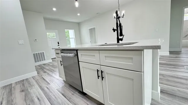 a kitchen with a sink cabinets and wooden floor
