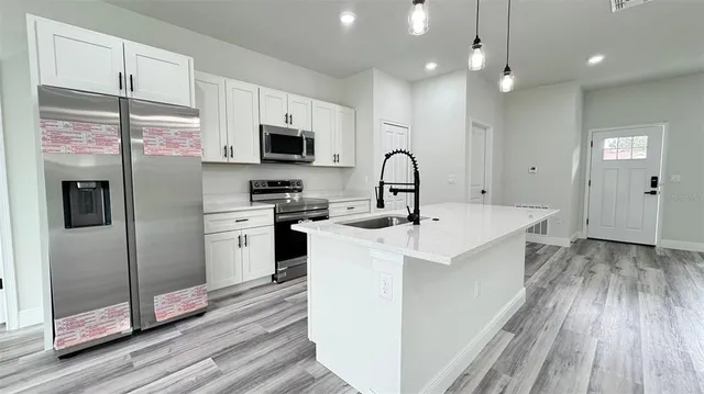 a kitchen with kitchen island a sink stainless steel appliances and counter space