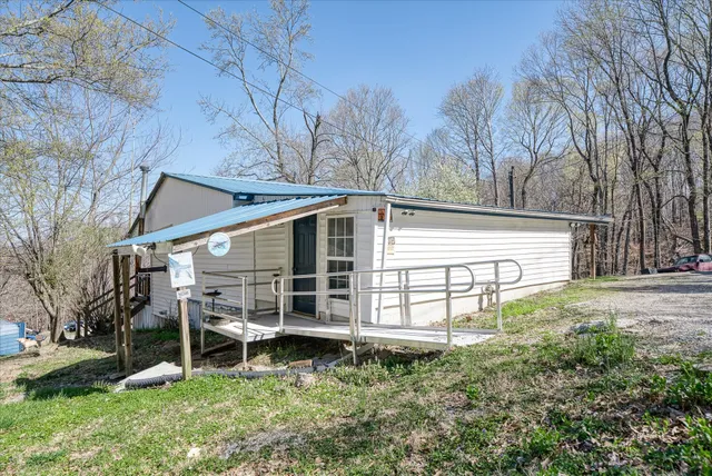 a view of a house with a yard and wooden fence