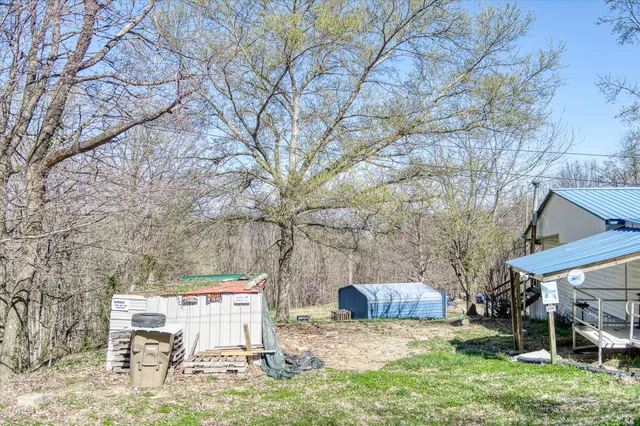 a view of a backyard with table and chairs under an umbrella