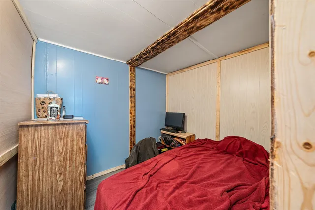 a bed room with a bed and a flat tv screen